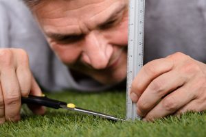 Man trying to cut grass perfectly